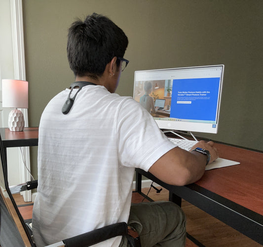 Real image of young man sitting up right with the Verulex Smart Posture Trainer sitting on his upper back. 